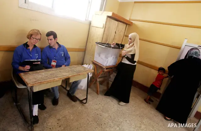 Egyptian voters cast their ballots presence of international observers at one of the polling stations during the first round of Egypt's presidential elections, at a polling station in Cairo, Egypt, 24 May 2012. for the f...