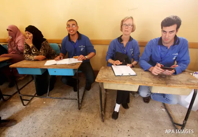 Egyptian voters cast their ballots presence of international observers at one of the polling stations during the first round of Egypt's presidential elections, at a polling station in Cairo, Egypt, 24 May 2012. for the f...
