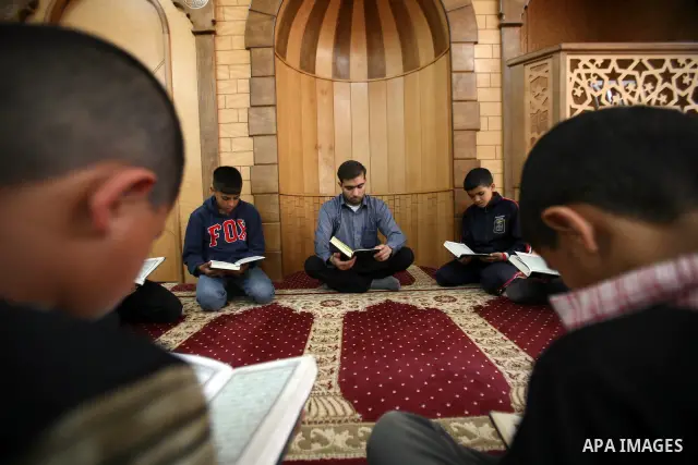 Palestinian orphan children read Qur'an at the Hebron's orphan house, in the West Bank city of Hebron 24 May 2012. Hebron's orphan house contain about 100 orphan children from ages 6 to 18 years old, and oversees some of...