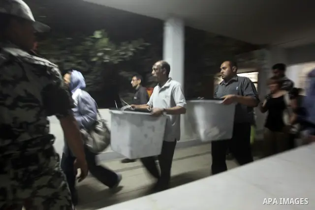 Egyptian election officials take sealed ballet boxs to count ballots of the first round of Egypt's presidential elections, in a polling station in Cairo, Egypt, at the end of the election's second day on 24 May 2012. Pol...