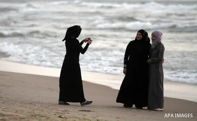 Palestinian girls take a photo on the beach of Gaza City on May 24, 2012. Gaza beach is the only outlet for the Palestinians after tightening the Israeli blockade on the Gaza Strip. Photo by Majdi Fathi