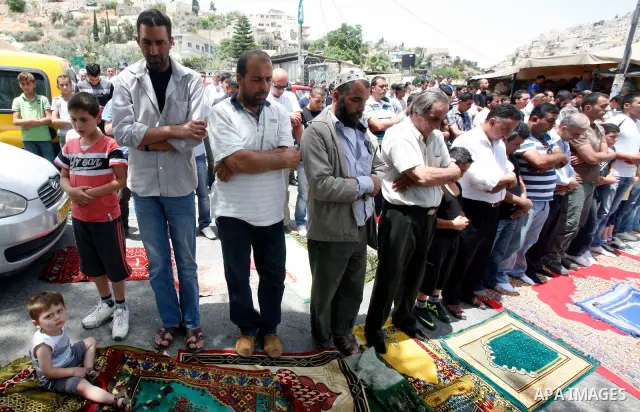 Palestinian Muslim worshippers attend Friday prayers outside a protest tent against the continuing 'Judaization of Jerusalem' by Jewish settlers, in the mostly Arab neighbourhood of Silwan in east Jerusalem on May 25, 20...