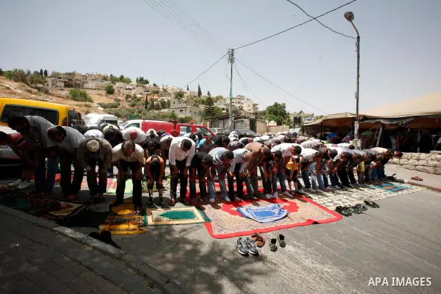 Palestinian Muslim worshippers attend Friday prayers outside a protest tent against the continuing 'Judaization of Jerusalem' by Jewish settlers, in the mostly Arab neighbourhood of Silwan in east Jerusalem on May 25, 20...