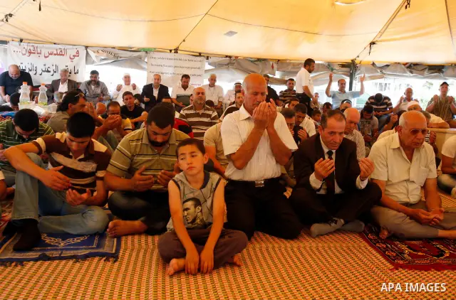 Palestinian Muslim worshippers attend Friday prayers inside a protest tent against the continuing 'Judaization of Jerusalem' by Jewish settlers, in the mostly Arab neighbourhood of Silwan in east Jerusalem on May 25, 201...