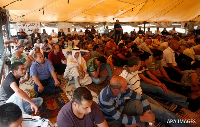 Palestinian Muslim worshippers attend Friday prayers inside a protest tent against the continuing 'Judaization of Jerusalem' by Jewish settlers, in the mostly Arab neighbourhood of Silwan in east Jerusalem on May 25, 201...