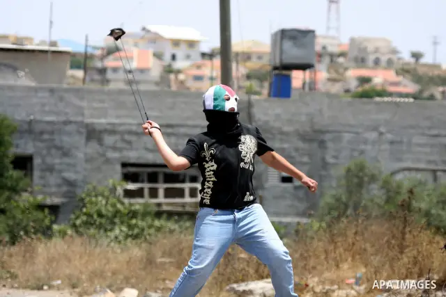 A Palestinian protester throws stone at Israeli soldiers during clashes in the northern West Bank village of Kufr Qaddum, near the Jewish settlement of Kdumim, on May 25, 2012. Photo by Wagdi Eshtayah