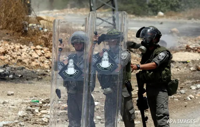Israeli soldiers wearing gas masks during clashes in the northern West Bank village of Kufr Qaddum, near the Jewish settlement of Kdumim, on May 25, 2012. Photo by Wagdi Eshtayah