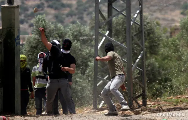 Palestinian protesters throw stones at Israeli soldiers during clashes in the northern West Bank village of Kufr Qaddum, near the Jewish settlement of Kdumim, on May 25, 2012. Photo by Wagdi Eshtayah