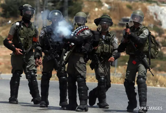 Israeli soldiers fire tear gas at Palestinian protesters during clashes between stone throwers and Israeli soldiers in the West Bank village of Nabi Saleh, near Ramallah, on May 25, 2012 following a protest against the c...