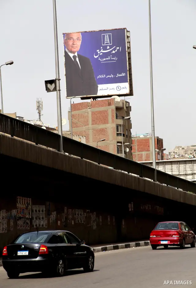 A defaced billboard of Egyptian presidential candidate Ahmed Shafiq stands in a street in Cairo May 25, 2012. Egypt looked set for a run-off presidential vote pitting Muslim Brotherhood candidate Mohammed Mursi against M...