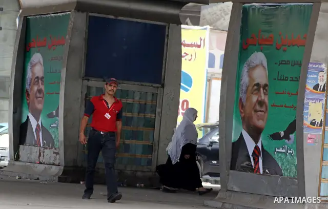 A campaign poster supporting presidential candidate Hamdeen Sabahi is posted outside a barbershop in Cairo, Egypt as people return to daily life after two days of voting in the country's presidential election Friday, May...