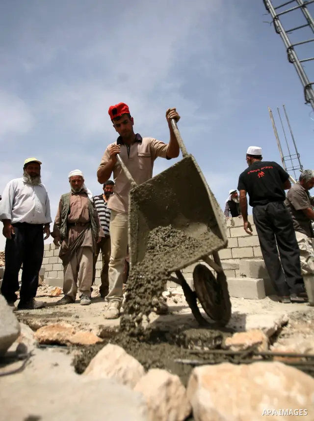 Palestinian workers build homes for Palestinians in the West Bank City of Hebron, on May 26, 2012 Palestinians whose houses were destroyed during Israeli military operations in West bank. Photo by Mamoun Wazwaz