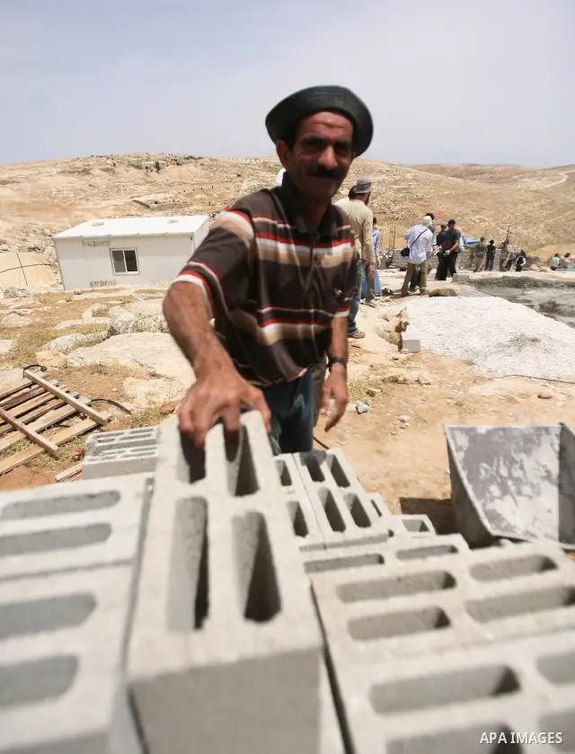 Palestinian workers build homes for Palestinians in the West Bank City of Hebron, on May 26, 2012 Palestinians whose houses were destroyed during Israeli military operations in West bank. Photo by Mamoun Wazwaz