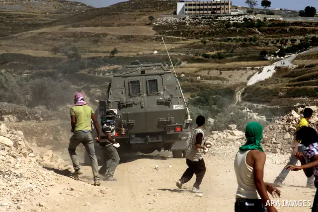 Palestinian Youths throw stones at Israeli soldiers after burnt agriculture fields by Jewish settlers in Oref village near the west bank city of Nablus. on May 26.2012. Photo by Nedal Shtieh.