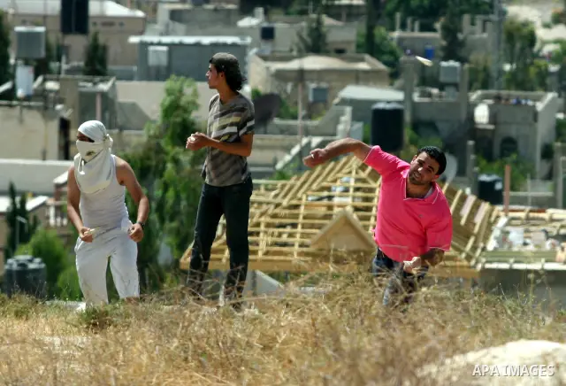 Palestinian Youths throw stones at Israeli soldiers after burnt agriculture fields by Jewish settlers in Oref village near the west bank city of Nablus. on May 26.2012. Photo by Nedal Shtieh.