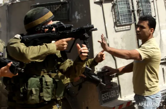 Palestinian protesters run for cover as Israeli forces fire in the air to disperse the crowd during clashes that followed the setting on fire of fields of grain and olive trees by hardline settlers from the Jewish settle...