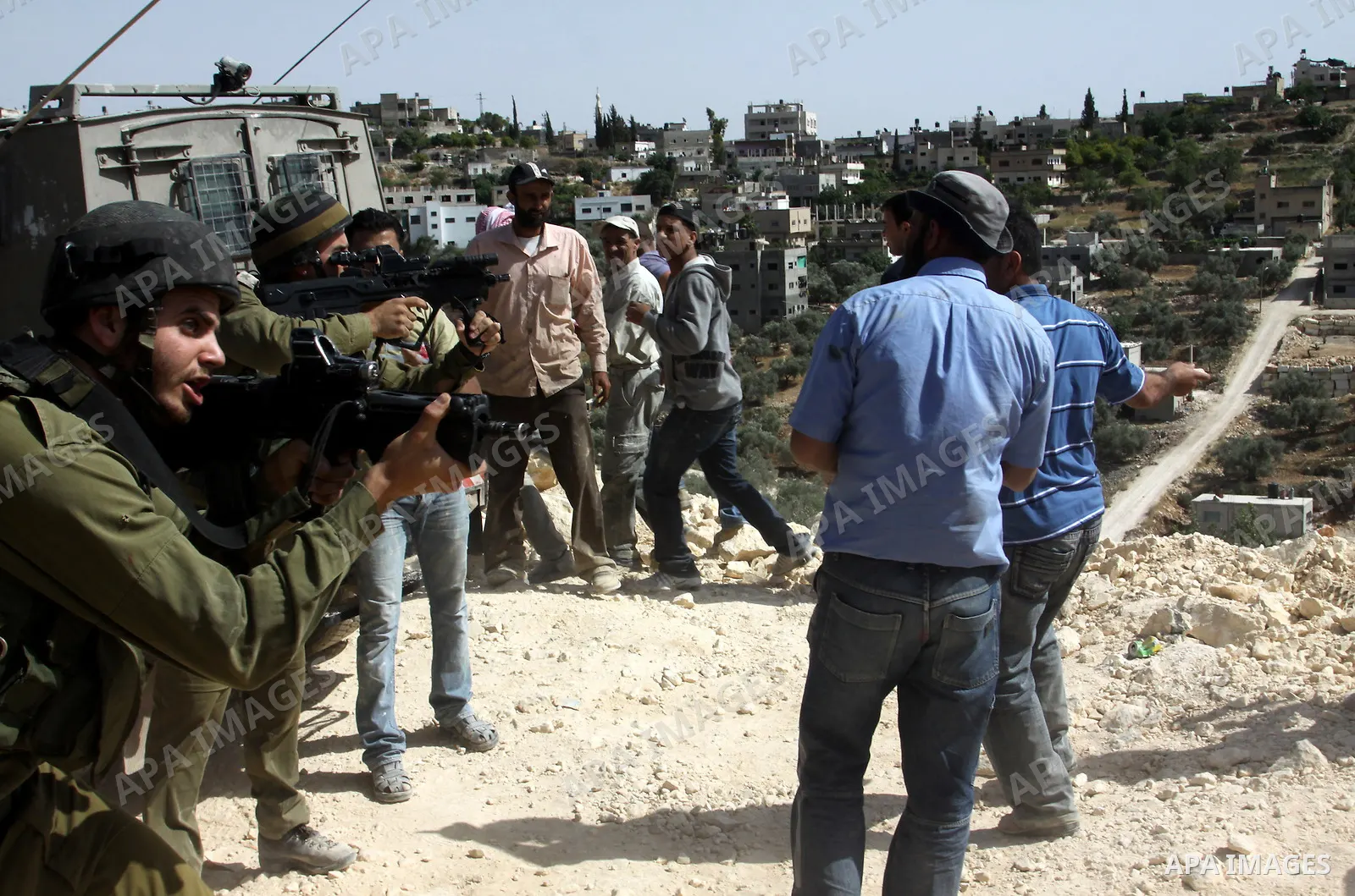 Palestinian protesters run for cover as Israeli forces fire in the air to disperse the crowd during clashes that followed the setting on fire of fields of grain and olive trees by hardline settlers from the Jewish settle...