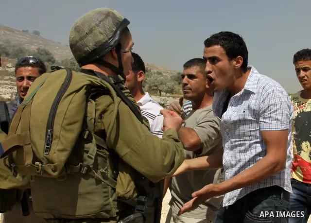 Palestinian protesters run for cover as Israeli forces fire in the air to disperse the crowd during clashes that followed the setting on fire of fields of grain and olive trees by hardline settlers from the Jewish settle...