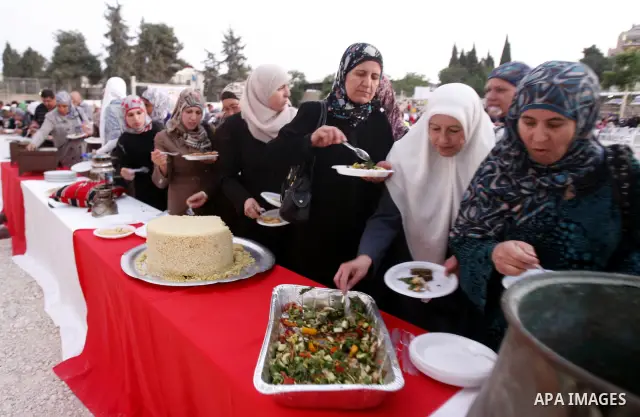 Palestinians serve food from the longest buffet table of natural and organic food, officially setting a new Guinness world record. on May 26, 2012 in Arab east jerusalem. The Palestinian banquet, prepared by Jerusalem lo...