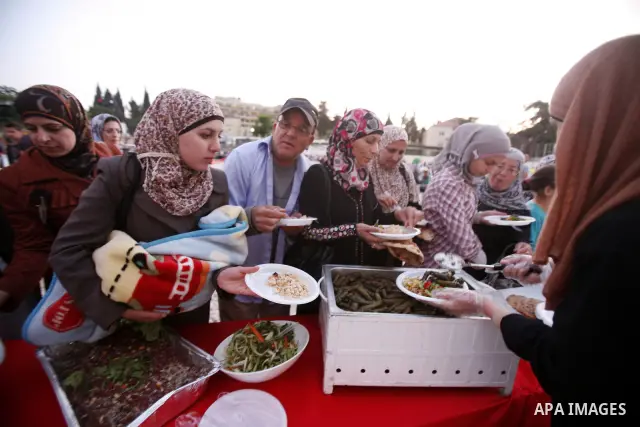 Palestinians serve food from the longest buffet table of natural and organic food, officially setting a new Guinness world record. on May 26, 2012 in Arab east jerusalem. The Palestinian banquet, prepared by Jerusalem lo...