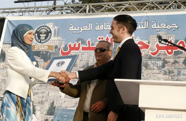 British Jack Brockbank , an international adjudicator from Guinness World Records, presents a certificate to Greek Orthodox Archbishop Theodosios (Atallah) Hanna for the longest buffet of natural and organic food setting...