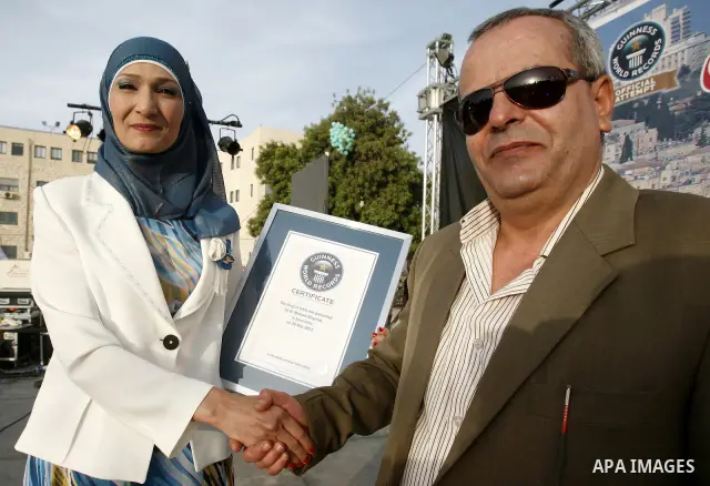 British Jack Brockbank , an international adjudicator from Guinness World Records, presents a certificate to Greek Orthodox Archbishop Theodosios (Atallah) Hanna for the longest buffet of natural and organic food setting...