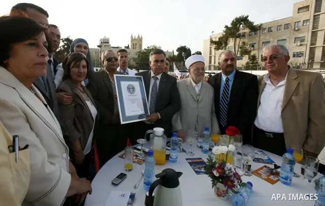 British Jack Brockbank , an international adjudicator from Guinness World Records, presents a certificate to Palestinian Prime Minister Salam Fayad for the longest buffet of natural and organic food setting a new guinnes...