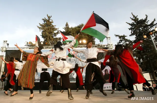 A Palestinian folkloric dance troupe performs during a celebration in Arab east jerusalem after the longest buffet of natural and organic food registered a new Guinness world record, on May 26, 2012 in Arab east jerusale...
