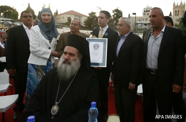 British Jack Brockbank , an international adjudicator from Guinness World Records, presents a certificate to Palestinian Prime Minister Salam Fayad for the longest buffet of natural and organic food setting a new guinnes...