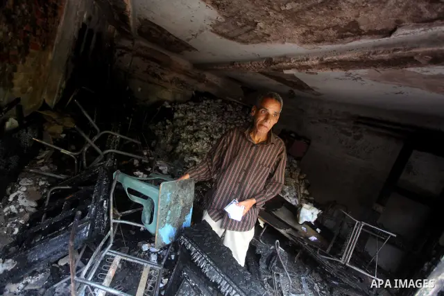 A man checks the scene inside the burnt campaign headquarters of candidate and former prime minister Ahmed Shafiq in Cairo May 29, 2012. A group of Egyptian protesters set fire to the headquarters on Monday, the state ne...