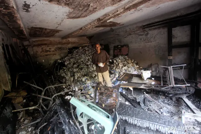A man checks the scene inside the burnt campaign headquarters of candidate and former prime minister Ahmed Shafiq in Cairo May 29, 2012. A group of Egyptian protesters set fire to the headquarters on Monday, the state ne...