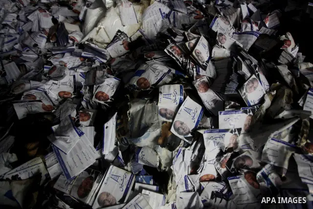 A man shows flyers of presidential candidate Ahmed Shafiq at the scene of the burnt campaign headquarters of Shafiq in Cairo May 29, 2012. A group of Egyptian protesters set fire to the headquarters on Monday, the state...
