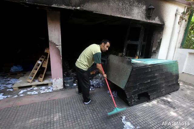 Egyptian Men remove the damages in the burnt campaign headquarters of candidate and former prime minister Ahmed Shafiq in Cairo May 29, 2012. A group of Egyptian protesters set fire to the headquarters on Monday, the sta...