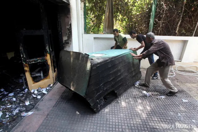 Egyptian Men remove the damages in the burnt campaign headquarters of candidate and former prime minister Ahmed Shafiq in Cairo May 29, 2012. A group of Egyptian protesters set fire to the headquarters on Monday, the sta...