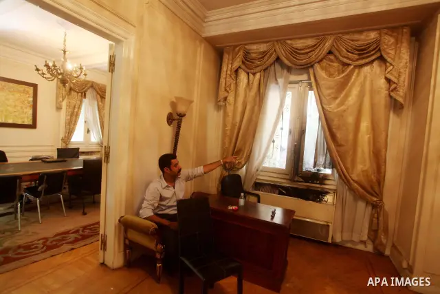 A man checks the scene inside the burnt campaign headquarters of candidate and former prime minister Ahmed Shafiq in Cairo May 29, 2012. A group of Egyptian protesters set fire to the headquarters on Monday, the state ne...