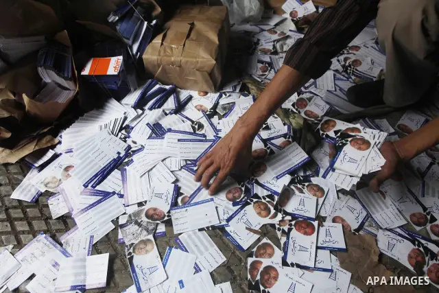A man shows flyers of presidential candidate Ahmed Shafiq at the scene of the burnt campaign headquarters of Shafiq in Cairo May 29, 2012. A group of Egyptian protesters set fire to the headquarters on Monday, the state...