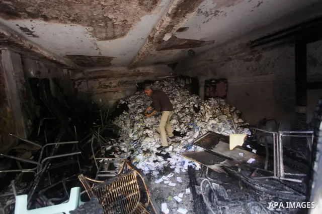 A man checks the scene inside the burnt campaign headquarters of candidate and former prime minister Ahmed Shafiq in Cairo May 29, 2012. A group of Egyptian protesters set fire to the headquarters on Monday, the state ne...