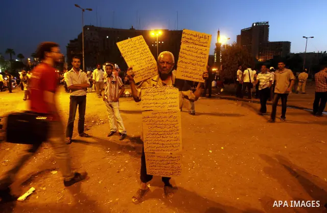 An Egyptian protester holds slogans against presidential candidates Mohammed Morsi and Ahmed Shafiq at Tahrir Square in Cairo May 29, 2012. According to full official results released Monday by the election commission. C...