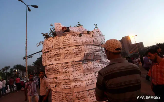 An Egyptian protester reads slogans against presidential candidates Mohammed Morsi and Ahmed Shafiq at Tahrir Square in Cairo May 29, 2012. According to full official results released Monday by the election commission. C...
