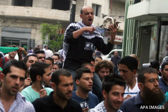Palestinian protestors bang on pots covered in pictures of Palestinian prisoners Mahmoud al-Sarsak and Akram al-Rikhawi, who are still refusing food a week after a deal was made to end a mass prisoner hunger strike, duri...
