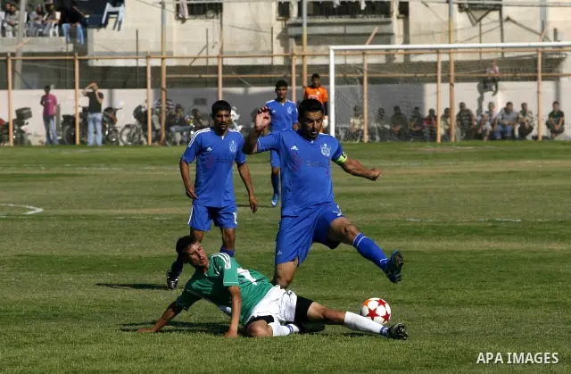 Players from Rafah Youth Club play against the players from Rafah Services Club during a football match in the League Cup of the Gaza Strip at Rafah Municipality Stadium in the southern Gaza Strip on May 30, 2012. Photo...
