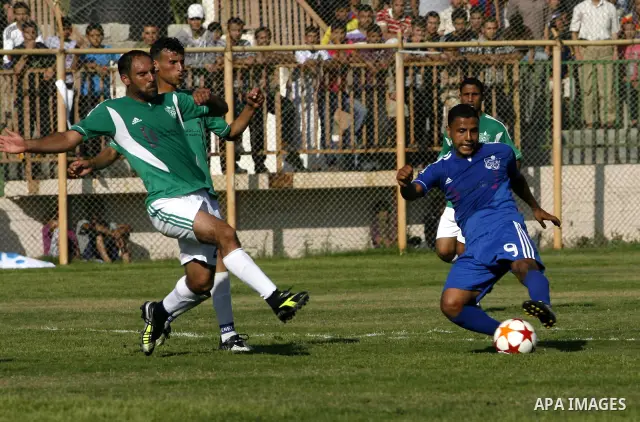 Players from Rafah Youth Club play against the players from Rafah Services Club during a football match in the League Cup of the Gaza Strip at Rafah Municipality Stadium in the southern Gaza Strip on May 30, 2012. Photo...