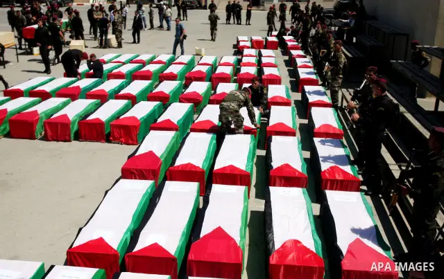 Palestinian security forces carry flag-draped coffins during preparations for the funeral procession of 91 Palestinians whose remains were returned by Israel in the West Bank city of Ramallah on May 31, 2012. Israel hand...