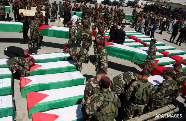 Palestinian security forces carry flag-draped coffins during preparations for the funeral procession of 91 Palestinians whose remains were returned by Israel in the West Bank city of Ramallah on May 31, 2012. Israel hand...