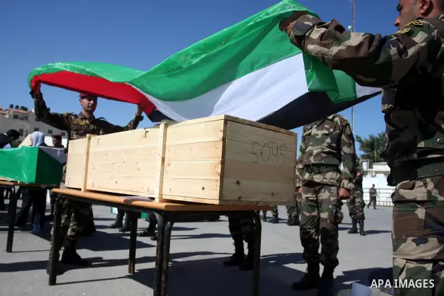 Palestinian security forces carry flag-draped coffins during preparations for the funeral procession of 91 Palestinians whose remains were returned by Israel in the West Bank city of Ramallah on May 31, 2012. Israel hand...