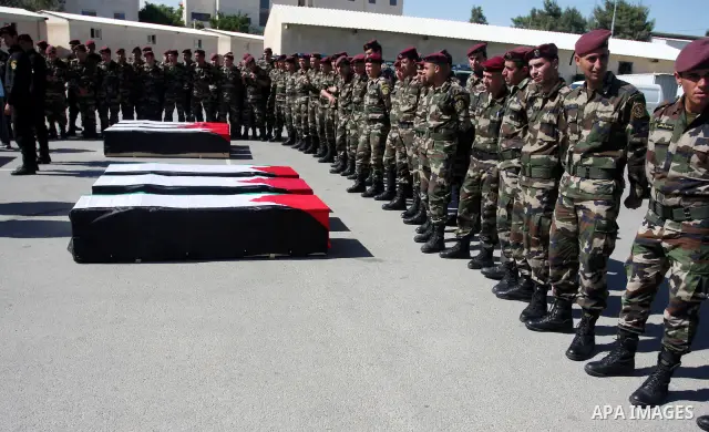Palestinian security forces carry flag-draped coffins during preparations for the funeral procession of 91 Palestinians whose remains were returned by Israel in the West Bank city of Ramallah on May 31, 2012. Israel hand...