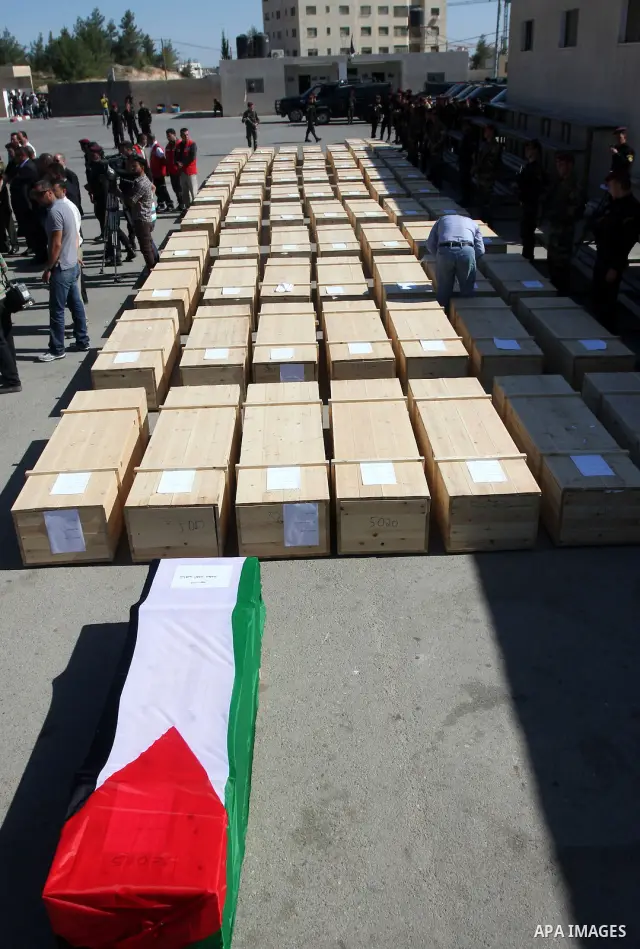 Palestinian security forces carry flag-draped coffins during preparations for the funeral procession of 91 Palestinians whose remains were returned by Israel in the West Bank city of Ramallah on May 31, 2012. Israel hand...