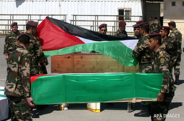 Palestinian security forces carry flag-draped coffins during preparations for the funeral procession of 91 Palestinians whose remains were returned by Israel in the West Bank city of Ramallah on May 31, 2012. Israel hand...