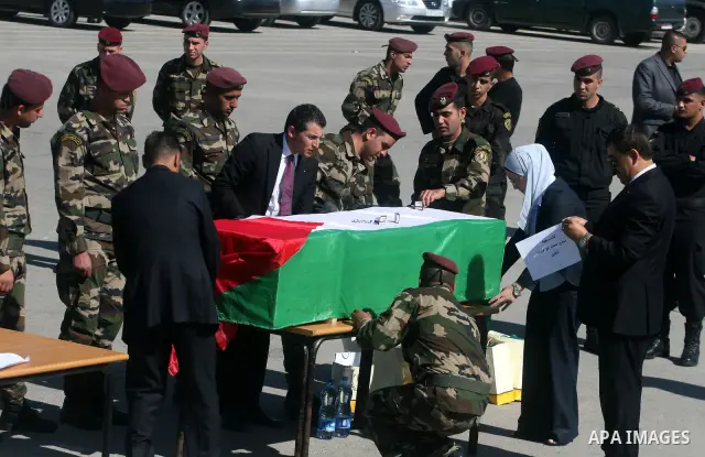 Palestinian security forces carry flag-draped coffins during preparations for the funeral procession of 91 Palestinians whose remains were returned by Israel in the West Bank city of Ramallah on May 31, 2012. Israel hand...
