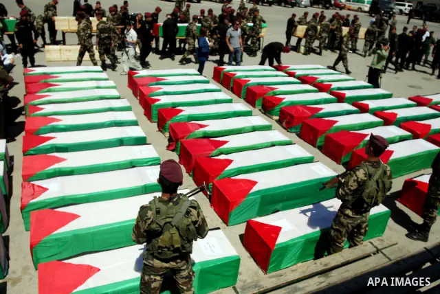 Palestinian security forces carry flag-draped coffins during preparations for the funeral procession of 91 Palestinians whose remains were returned by Israel in the West Bank city of Ramallah on May 31, 2012. Israel hand...